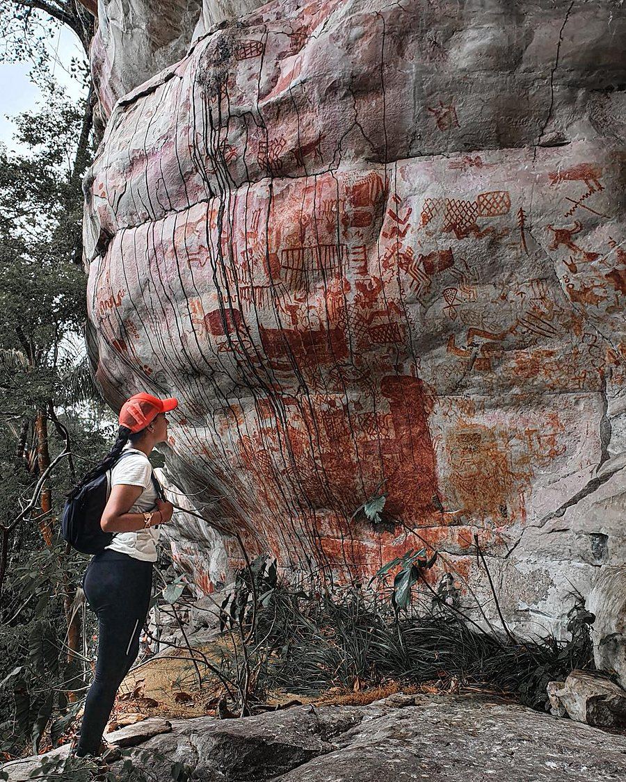 Viajera observando los pictogramas en la roca