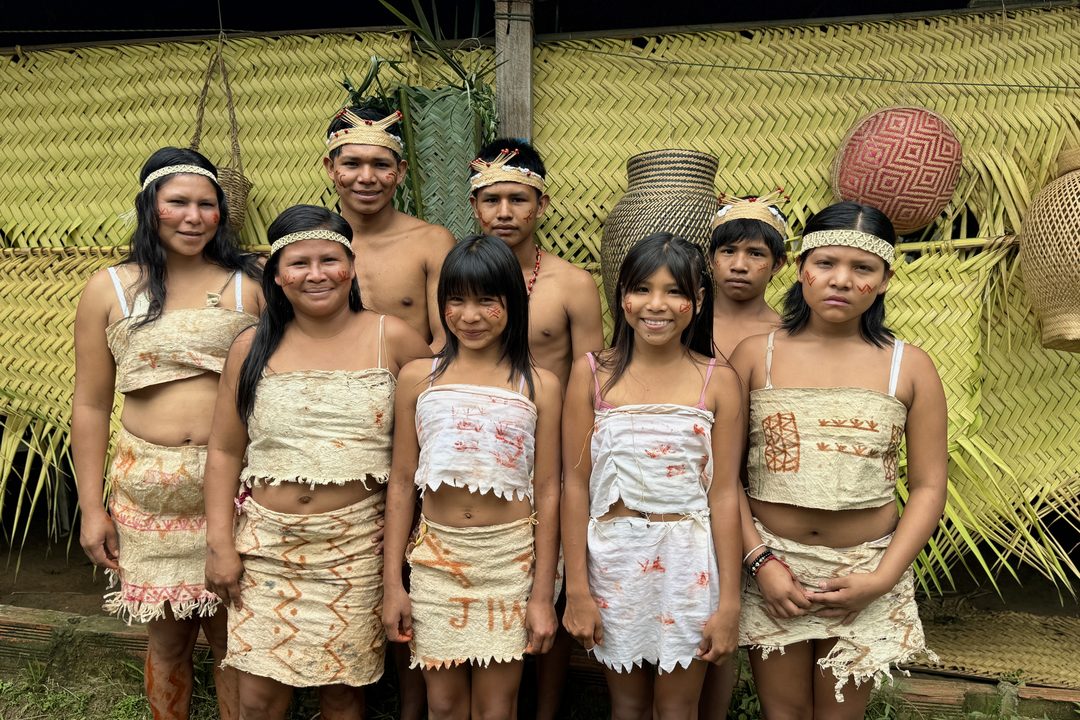 Comunidad en traje tradicional frente a la maloka