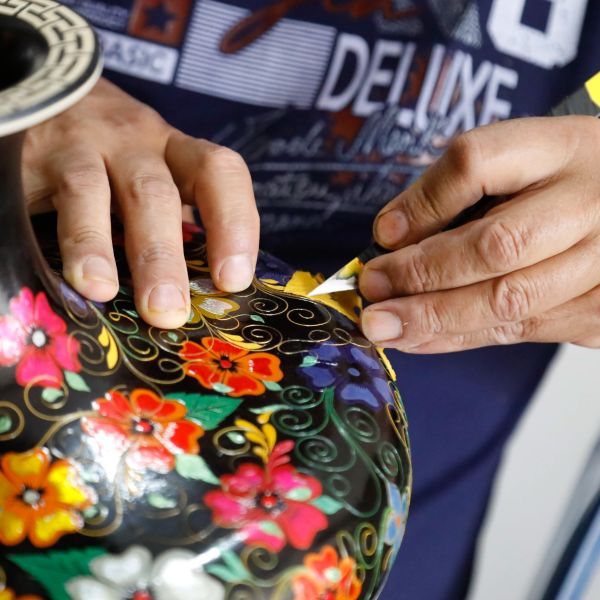 artesano decorando jarron con flores